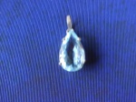 Pingente em prata, adornado com pedra azul, provavelmente água marinha na forma de gota. 