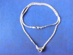 Gargantilha em metal prateado com pingente em forma de coração com crista. (bijuteria.