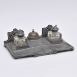 Grande tinteiro de mesa alemão corca 1900 provavelmente WMF estilo regence em pewter cinzelado c/ motivos neo clássico recipiente em grosso cristal (01 c/ lascado na base) porta carta e campanhia. 37x21cm