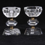Par de castiçais provavelmente romenos estilo art deco, em grosso cristal de rocha lapidado e facetado em ponta de diamante, guarnição em metal dourado, alt. 10cm.
