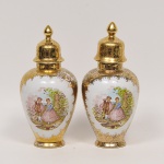 Par de potishes em porcelana branca e dourada decorada em esmalte, galeria central com cena galante. Med: 29cm