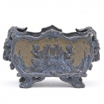 Antigo Cacheopot em terracota italiana ricamente decorada em relevo com flores, folhas e querubins musicistas, galerias laterais adornadas com busto de alce. Peça assinada e numerada. Med: 11 x 22 x 15cm