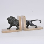 Par de serre livres confeccionados em mármore e adornados com escultura em metal patinado e cinzelado representando "Leão" Med: 19 x 12 x 15cm