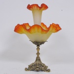 Belo centro de mesa tulipeira com base em bronze dourado e ricamente cinzelado e bojo em vidro artístico de murano nos tons laranja e leitoso com bordas em babados. Med: 43cm
