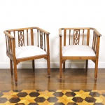 Par de poltronas no estilo colonial confeccionadas em madeira nobre entalhada, encosto vazado com galeria trabalhada e assento estofado e revestido em tecido na cor cinza rajado. Med: 74 x 54 x 44cm