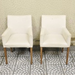 Par de poltronas no estilo moderno com assento, braços e encosto forrados em tecido na cor branca pés em madeira nobre. Med: 88 x 52 x 57cm (No Estado)