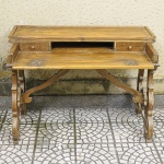 Escrivaninha no estilo rústico confeccionada em madeira nobre entalhada com duas gavetinhas, pés torneados e recurvos e tampo articulado. Med: 114 x 95 x 76cm