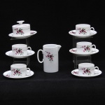Lote composto por 07 peças em porcelana na tonalidade branca decorada em esmalte com flores e folhas composto po: uma leiteira, uma manteigueira e 05 xícaras para cha com pires