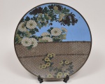 Imponente e antigo medalhão chinês em metal esmaltado a técnica cloisonné do Século XIX ricamente decorado com flores e folhas. Peça apresenta desgastes no esmalte e pequeno amassado em sua borda. Med: 45cm de diâmetro