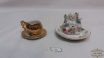 Lote com miniaturas em porcelana, sendo 1 bunda ,1 xicara , pratinho.Medidas: maior 5cm de altura menor 3cm de altura.