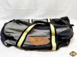 Bolsa de mão em nylon cinza, preto e amarelo com alça lateral. Medindo 55cm de comprimento.