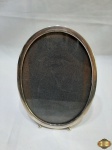 Porta retrato oval em prata de lei 925. Medindo 20,5cm x 15cm. Pesando 73 gramas.