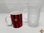 Lote de 2 canecas do Flamengo, sendo uma em porcelana e uma em vidro fosqueado. Medindo a maior 14cm de altura.