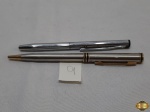 Lote de uma caneta esferográfica Crown e uma lapiseira Sheaffer. A lapiseira está sem ponteira e a caneta necessita de carga.