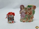 Lote composto de escultura de menina e saleiro de naipes em porcelana com policromia. Medindo a escultura 12,5cm de altura.