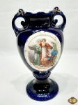 Vaso floreira em porcelana azul cobalto com cena galante. Medindo 21cm de altura.