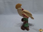 Escultura de ave cracatua em porcelana com policromia. Medindo 19cm de altura. Com leve bicado na crista.