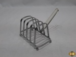 Porta torrada em aço inox com alça em acrílico. Medindo 11cm x 6,5cm x 7,5cm de altura.