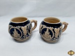 Par de canecas para ponche em porcelana alemã trabalhada com relevos. Medindo 9,5cm de diâmetro x 9cm de altura.