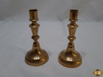 Par de castiçal em metal dourado com coluna torneada. Medindo 14,5cm de altura. Uma delas esta com o parafuso frouxo.