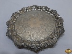 Salva redonda bandeja com pé em prata 90 EPNS, cinzelada com relevos na borda. Medindo 27,5cm de diâmetro x 3cm de altura.