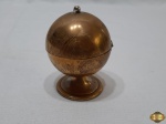 Isqueiro de mesa em metal dourado na forma de globo. Medindo 8,5cm de altura. Necessita de fluido.