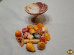 Pequena fruteira com diversas frutas em pedra para decoração. Medindo a fruteira 10cm de diâmetro x 7cm de altura. Fruteira com restauro no pé.