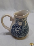 Leiteira em porcelana com pintura carruagem. Medindo 11,5cm de altura. Com restauro na alça.