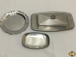 Lote composto de manteigueira, petisqueira e salva em aço inox. Medindo a manteigueira 22cm x 12cm x 5cm de altura.