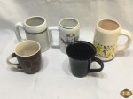 Lote composto de 5 canecas diversas em porcelana. Medindo a maior 14,5cm de altura.