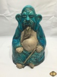Escultura de budista sentado em cerâmica vitrificada. Medindo 33cm de altura. Com uma perda na bengala.