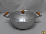 Panela com 2 alças e tampa em alumínio, alças em madeira. Medindo 29cm de diâmetro x 10,5cm de altura.