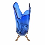 MURANO - Elegante vaso em tons de azul  translúcido. Base e borda rematadas com belíssimas ondulações.  Acompanha base em metal com pátina dourada apoiada por 4 pés estilizados. .Exemplar antigo e em perfeito estado de conservação. Dimensões: 38 cm  x 18 cm x 16 cm.