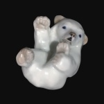 Delicado e gracioso Filhote de Urso Polar em fina porcelana Européia. Estatueta numerada no fundo. Exemplar antigo, de coleção e em perfeito estado. Dimensões: 6 cm x 7 cm x 5 cm.