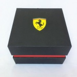 Robusto  estojo Scuderia Ferrari para Relógios. Fino acabamento, material exterior emborrachado, parte interna com detalhes trançados. Sistema de abertura sob pressão. Exemplar difícil de ser encontrado e em excelente estado de conservação. Dimensões: 9 cm x 12,5 cm x 12,5 cm.