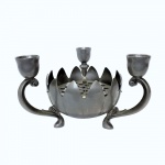 Interessante e  antigo artefato em metal prateado com bordas no formato de pétalas. Bowl com chapa removível, apoiada por três  pés curtos e recurvos; hastes no formato de voluta com copos para três velas. Dimensões: 12 cm altura x 20 cm diâmetro.