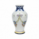 CARVALINHO PORTO - Vaso no feitio balaustre, cerâmica portuguesa decorada com flores, folhagens e laçarotes. Selo de autenticidade no fundo. Exemplar antigo e em excelente estado de conservação. Dimensões:  27 cm de altura.