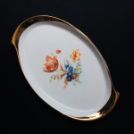 Linda bandeja em fina porcelana, anos 50,  decorada com arranjos florais e largas faixas nas extremidades pintadas à Ouro. Exemplar em excelente estado. Dimensões: 29 cm x 18 cm.