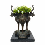 Caldeiro Trípode cerimonial de origem Oriental, construído em bronze e  rematado com detalhes vegetalistas e alças no formato de cabeça de dragão. Possivelmente séc 19. Exemplar antigo e em excelente estado de conservação. Acompanha base em granito preto.  Dimensões totais: 23 cm x 18 cm.
