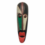 Máscara de coleção em madeira talhada, proveniente da Indonésia, com detalhes em tom de branco, verde e vermelho.Exemplar rústico com falhas na pintura. Dimensões: 48 cm x 15 cm x 10.