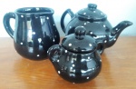 Mimoso conjunto de chá em cerâmica na cor preta com poa branco, contendo: leiteira, bule para chá e açucareiro - Alturas: 12 cm, 14 cm e 11 cm