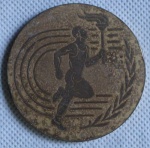 Medalha Esportiva - Anverso maratonista correndo com a tocha e no canto direito um ramo de Oliveira - Reverso logotipo dos Jogos Olímpicos com inscrições em grego nas bordas. Diam. 6cm.