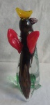 Escultura de Pássaro pousado em tronco de árvore em murano multi-colorido, com folhagens na base, ínfimo bicado na ponta do tronco, Alt.28cm.