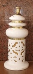 Abajour circa 60,  em porcelana branca. Corpo com motivos geométricos vazados. Guarnições em metal amarelo. Falta a base. Med.: 55 cm de altura