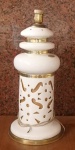 Abajour circa 60,  em porcelana branca. Corpo com motivos geométricos vazados. Guarnições em metal amarelo. Med.: 55 cm de altura