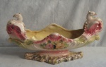 Imponente floreira em porcelana na cor rosa e branca com decoração floral e douração (apresenta desgaste), extremidades decorada com pássaros. Medindo: 23 x 43 x 16 cm. Restauro na peça. Medindo: 23 x 43 x 16 cm.