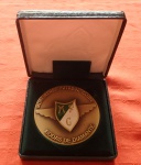 Medalha em Bronze no estojo Original  - Anverso Em relevo escudo do Moreirense Futebol Clube em laca verde e branca com azas saindo por trás, nas bordas a inscrição Moreirense futebol clube bodas de Diamante. Verso - ao Centro em Relevo arquibancada do clube gravado 75 anos. Datado 1938- 2013. Diam. 7,5cm