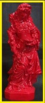 Grupo escultórico em estuque laqueado no padrão vermelho representando dama segurando vaso numa mão e ramo na outra. Alt.= 30cm.