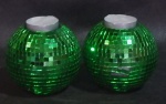 Par de castiçal em forma de globo de discoteca revestido com vidro verde, um apresenta falhas. med. 30 cm de circunferência com 10 cm de altura.