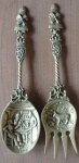 Lote com dois talheres decorativos em bronze ricamente cinzelado, colher decorada em relevo com cenas de taberna e o Garfo decorado em relevo com cenas do campo - med. 40 e 37 cm